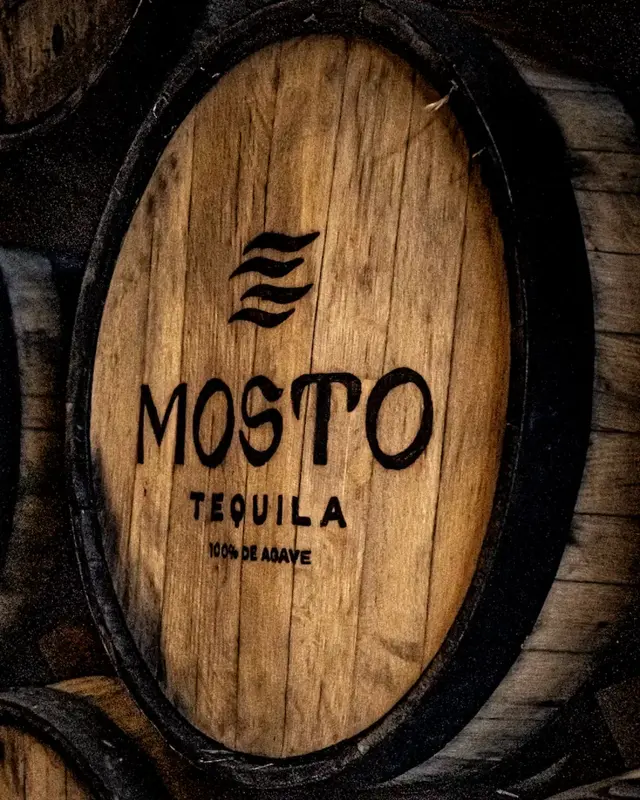 Mosto-branded bourbon barrels resting in the distillery